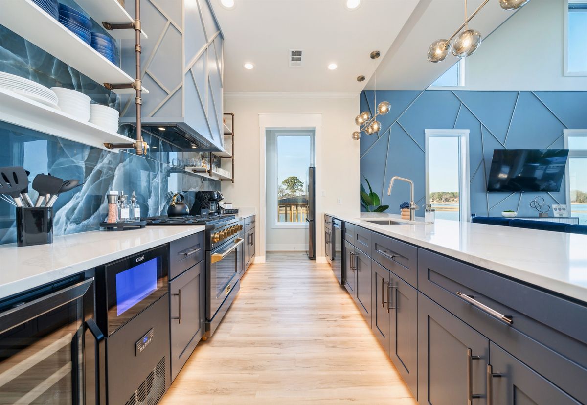 Kitchen remodel with navy cabinetry, a blue stone slab backsplash, open shelving, a brass-trimmed range and quartz countertops.